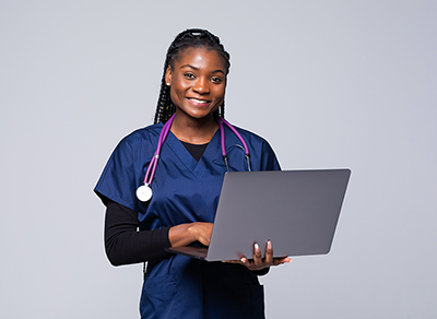 women in blue scrubs holding a laptop.